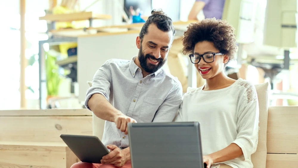 Two people looking at open laptops