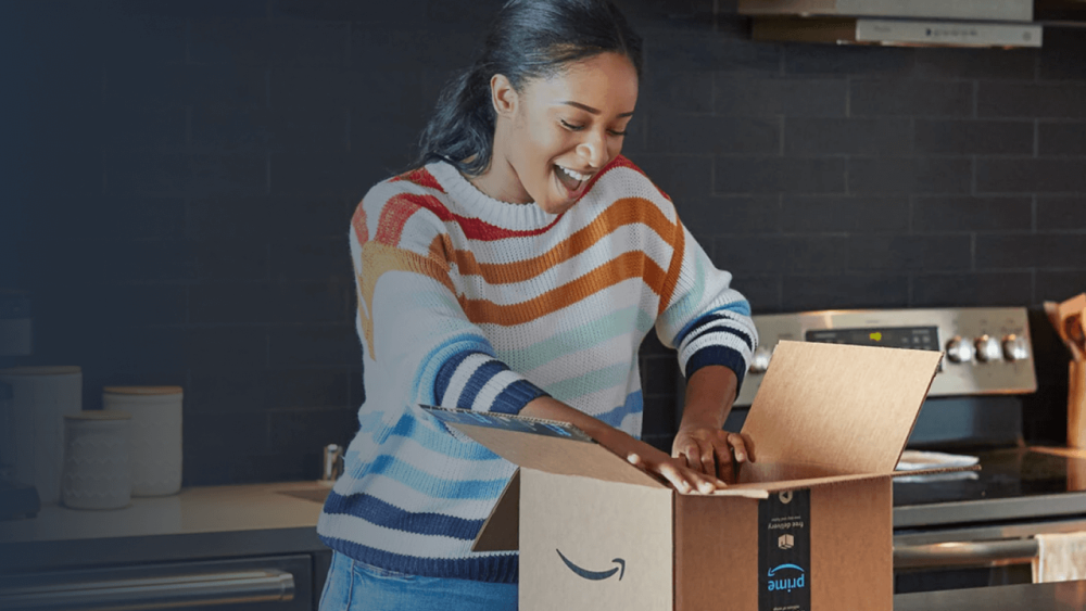 Smiling person in kitchen opening a package delivery