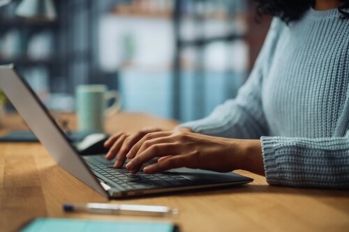 Closeup of person's hands typing on a laptop computer