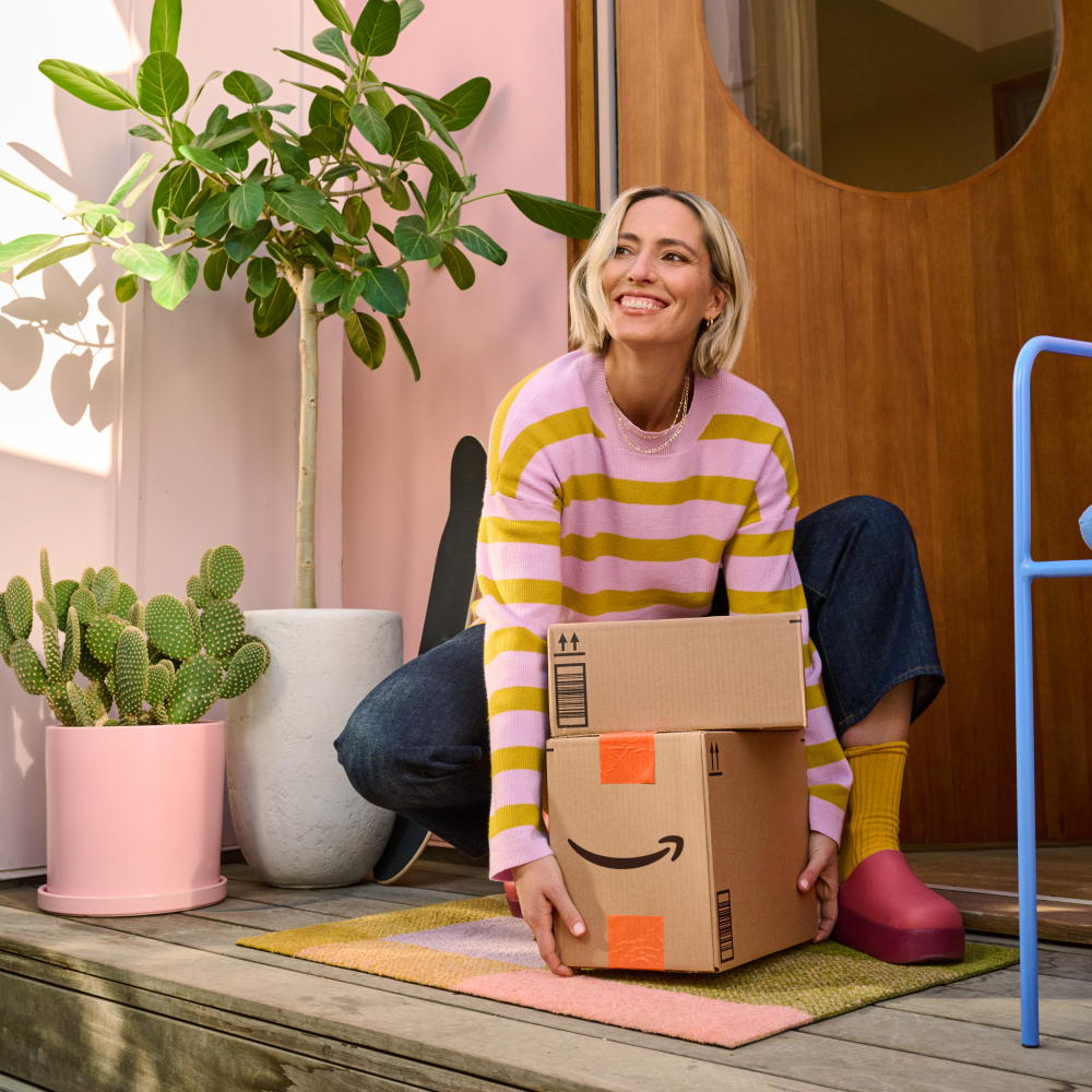 Person looking at phone and item from delivery package.