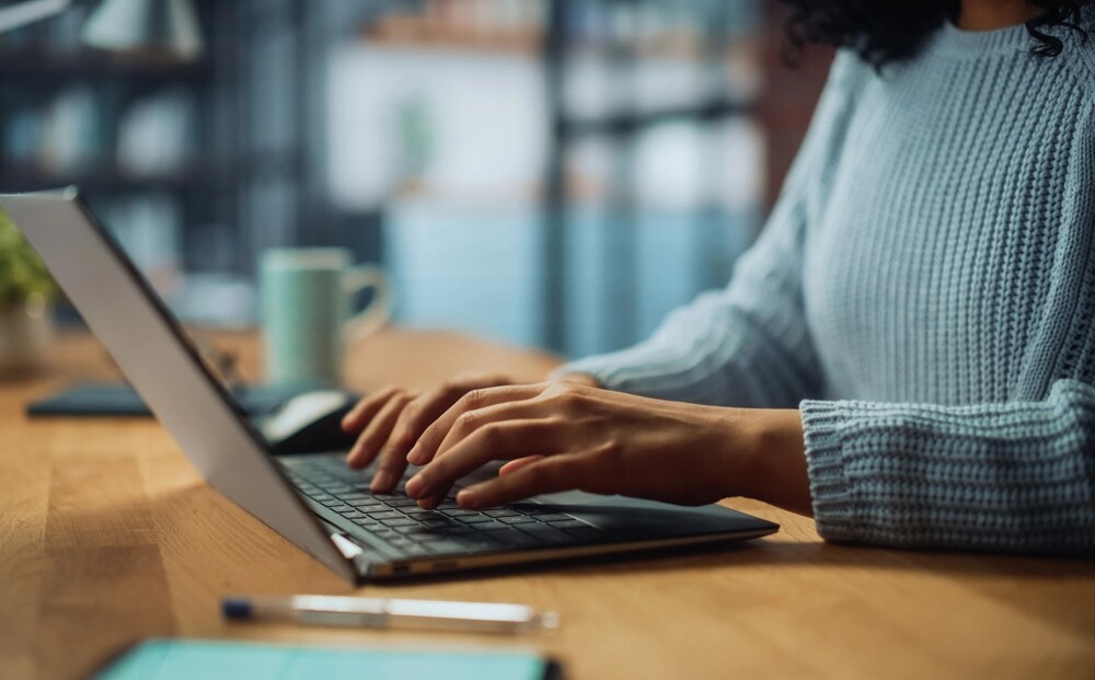 Closeup of person's hands typing on a laptop computer